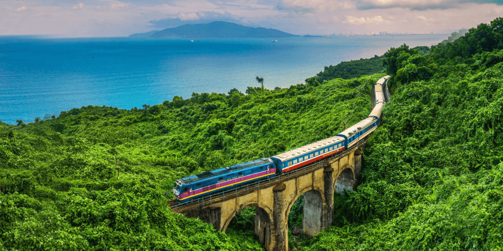 Travelers pass through the famous Hai Van Pass, where mountains dramatically overlook the ocean