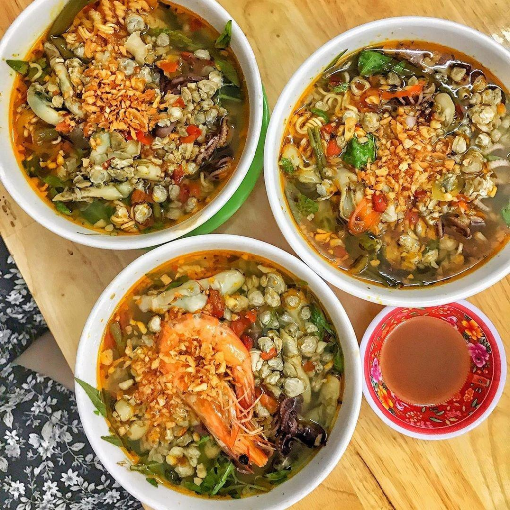 The sweetness of clams blends with chili heat, fresh herbs, and crunchy toppings to create multiple layers of texture in every bite.