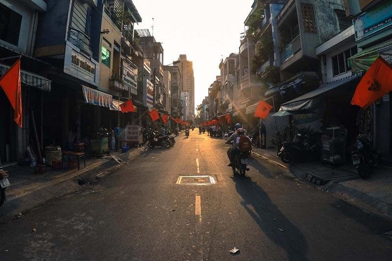 Nearby, food vendors serve steaming bowls of noodle soup while customers sit on small plastic stools chatting with friends and neighbors.