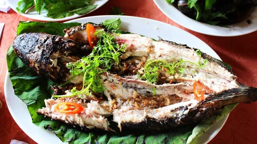 Like many Mekong Delta specialties, the fish is served with rice paper, fresh herbs, vegetables, and dipping sauces.